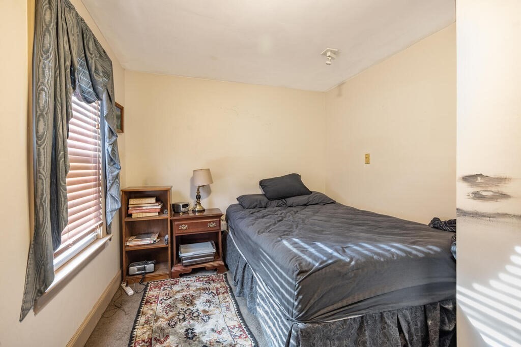 9 Cross Street Somerville, MA 02145 - Photo 12 of 18 a bedroom with a bed and a large window