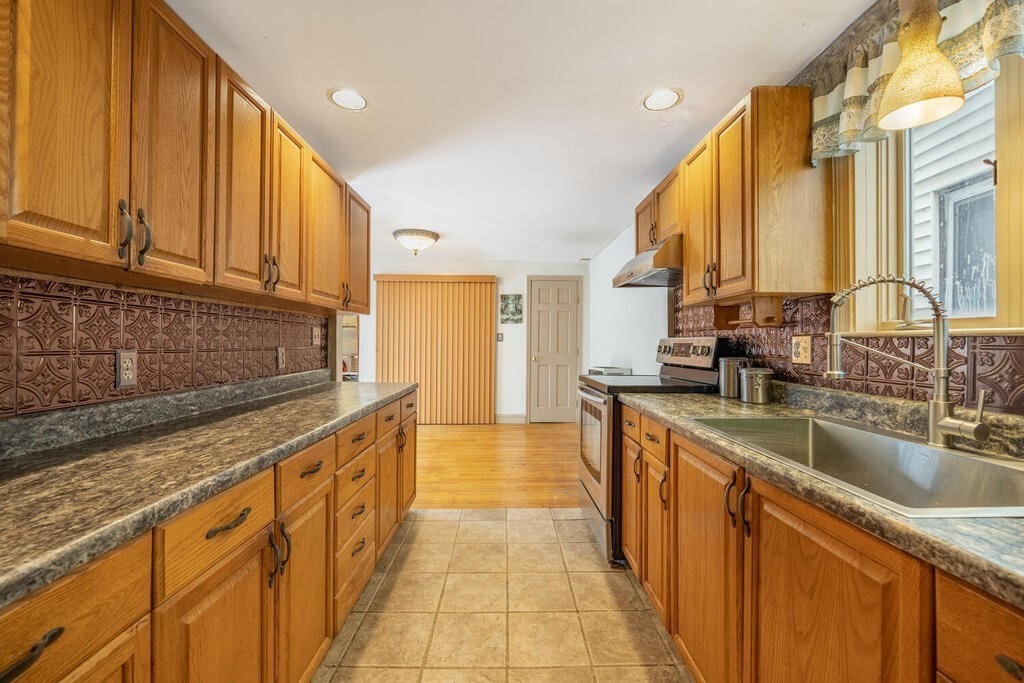 9 Cross Street Somerville, MA 02145 - Photo 10 of 18 a kitchen with stainless steel appliances granite countertop a sink a stove and cabinets