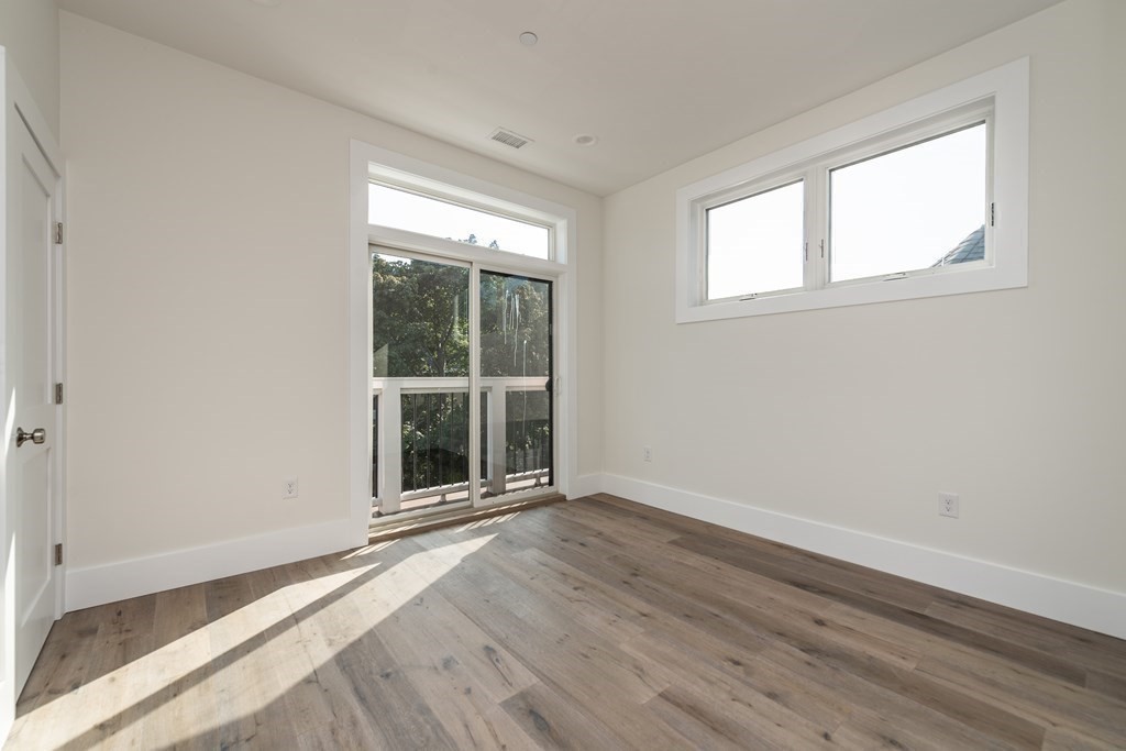 116 School Street, Unit 2 Boston, MA 02119 - Photo 13 of 24 a view of an empty room with wooden floor and a window