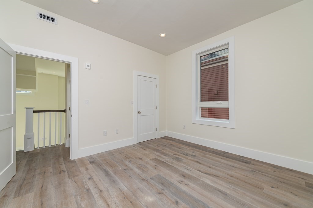 116 School Street, Unit 2 Boston, MA 02119 - Photo 15 of 24 wooden floor in an empty room with a window