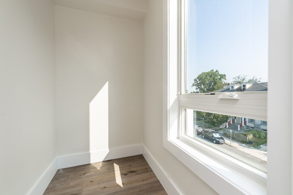 116 School Street, Unit 2 Boston, MA 02119 - Photo 21 of 24 an empty room with wooden floor and a window