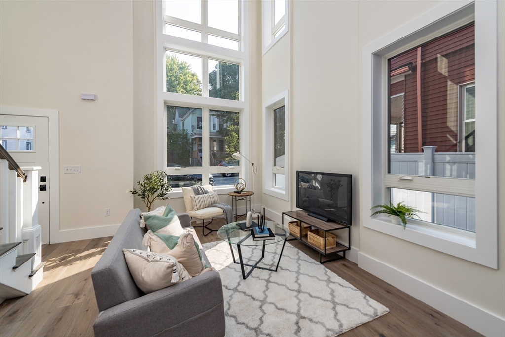 116 School Street, Unit 2 Boston, MA 02119 - Photo 8 of 24 a living room with furniture a flat screen tv and a window