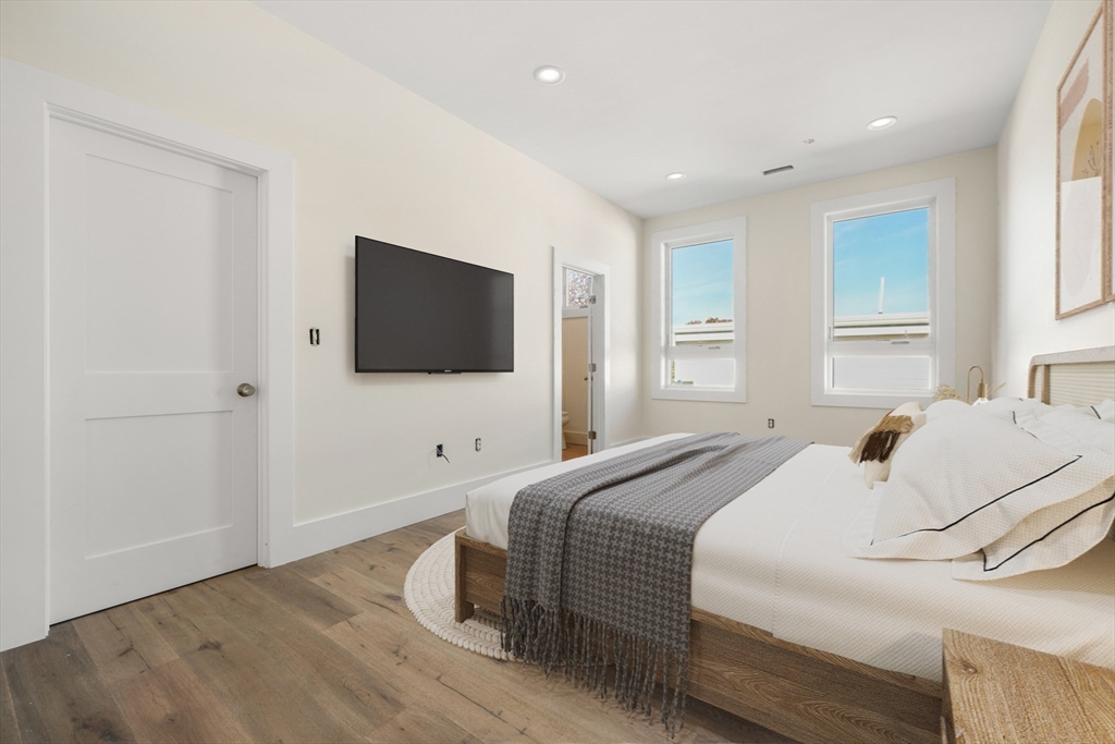 116 School Street, Unit 2 Boston, MA 02119 - Photo 9 of 24 a bedroom with a bed and a flat screen tv
