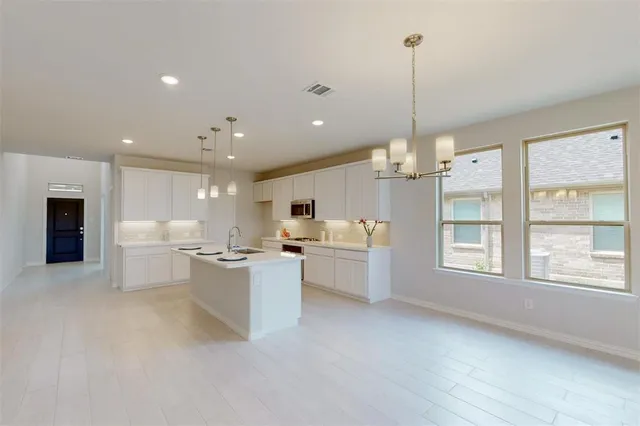 a open kitchen with stove and white cabinets