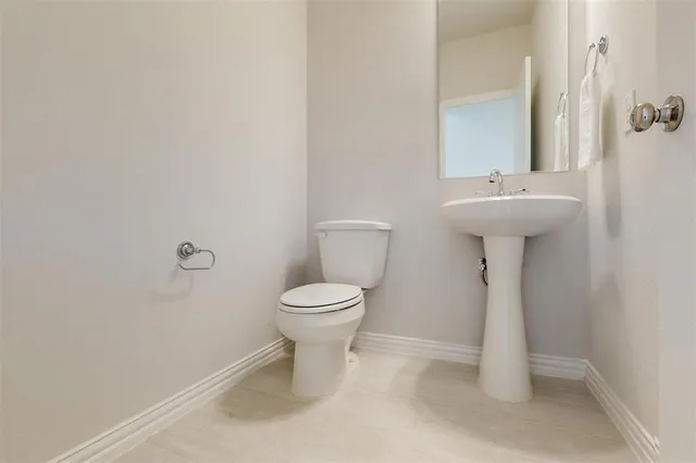 a bathroom with a sink toilet and a mirror