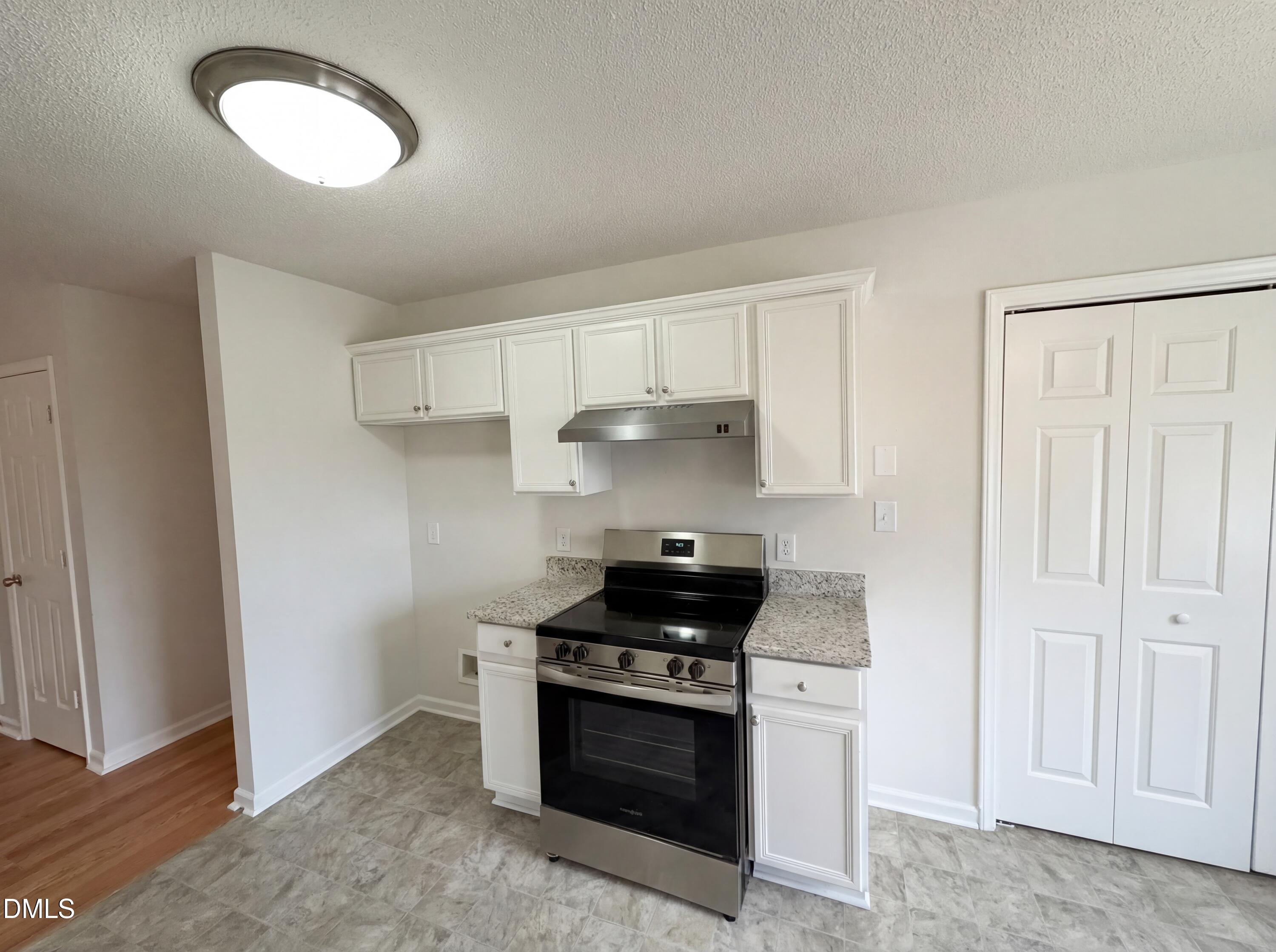 83 Eagle Rock Place Clayton, NC 27520 - Photo 13 of 16 a kitchen with stainless steel appliances granite countertop white cabinets and a stove