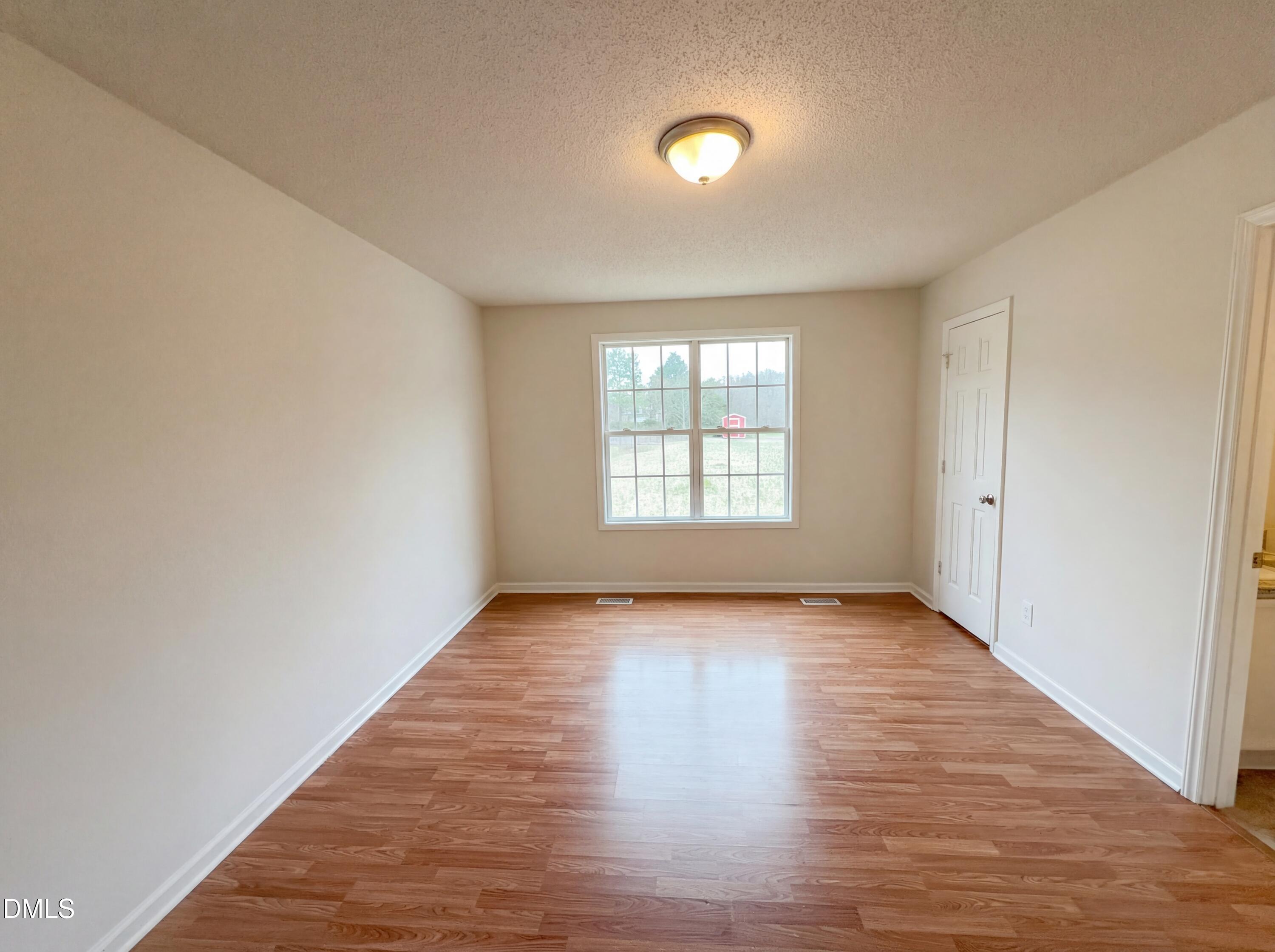 83 Eagle Rock Place Clayton, NC 27520 - Photo 4 of 16 an empty room with wooden floor and windows