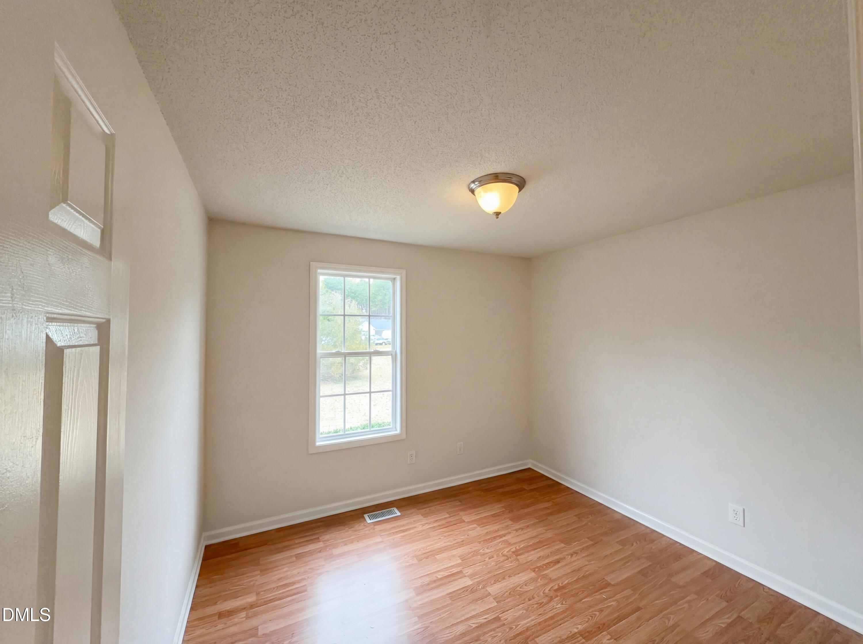 83 Eagle Rock Place Clayton, NC 27520 - Photo 10 of 16 an empty room with wooden floor and windows