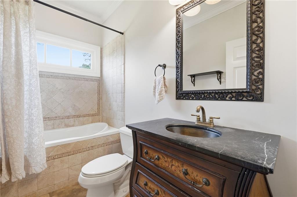 3535 Dr Bramblett Road Cumming, GA 30028 - Photo 51 of 91 a bathroom with a granite countertop sink a toilet a mirror and shower
