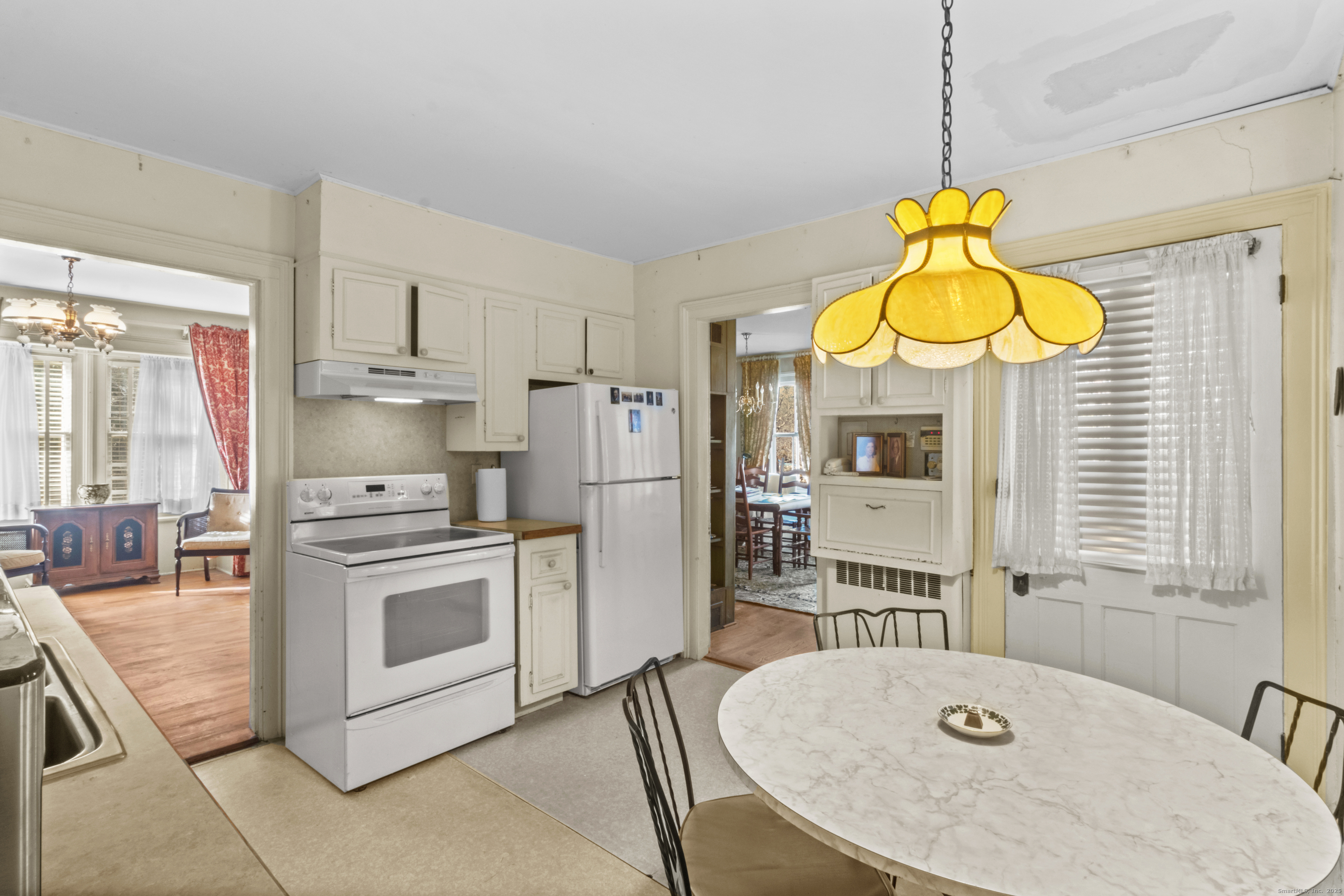 179 Verna Hill Road Fairfield, CT 06824 - Photo 11 of 36 a kitchen with stainless steel appliances granite countertop a sink a stove a refrigerator a microwave oven with white cabinets and wooden floor