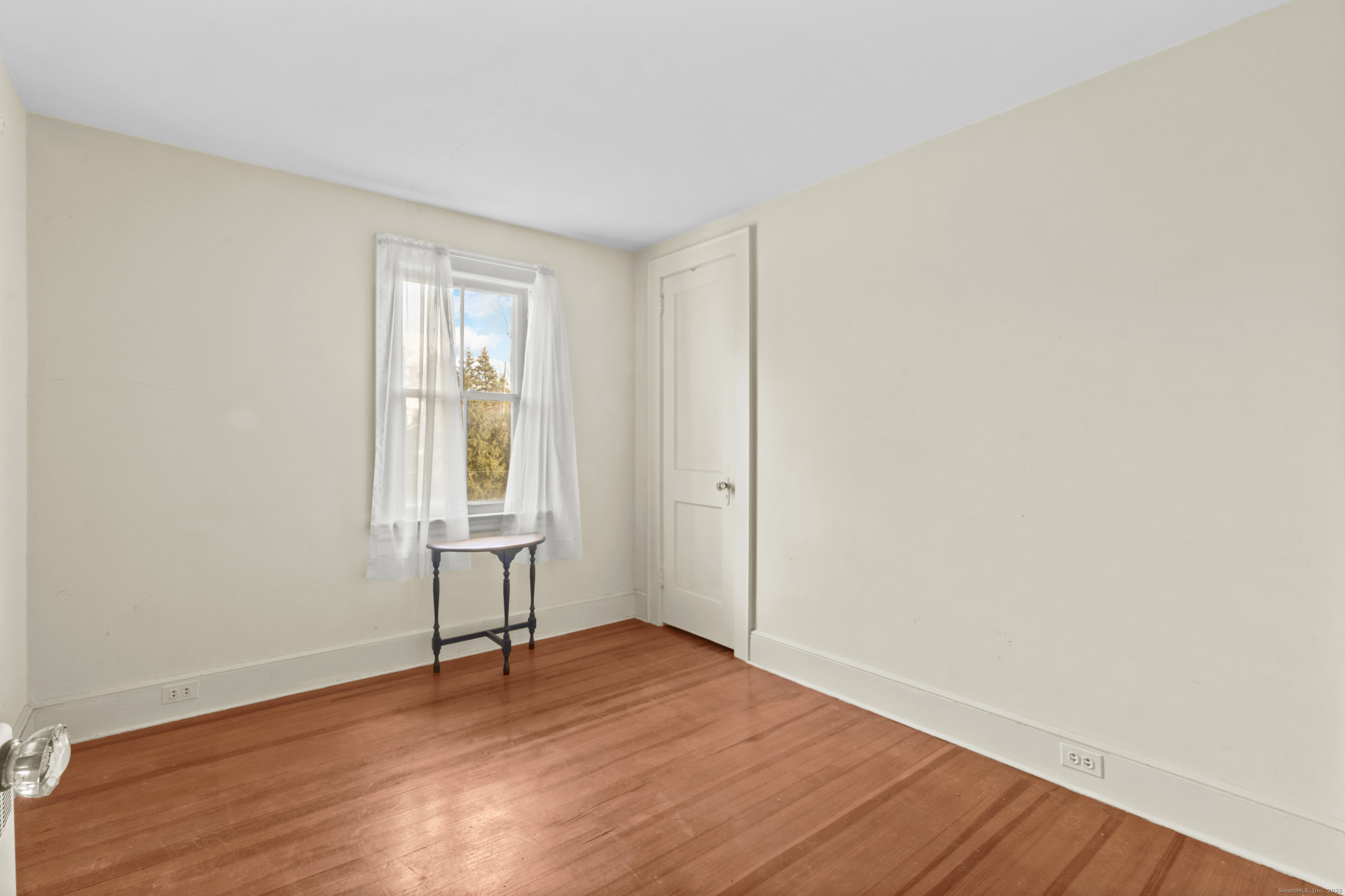 179 Verna Hill Road Fairfield, CT 06824 - Photo 16 of 36 a view of an empty room with wooden floor and a window