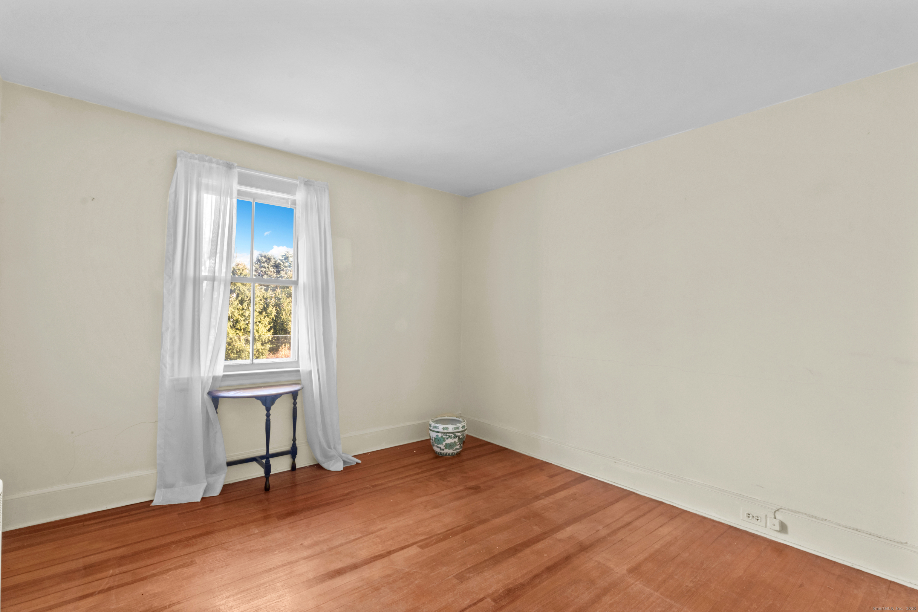 179 Verna Hill Road Fairfield, CT 06824 - Photo 20 of 36 an empty room with wooden floor and windows