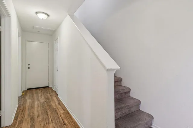 a view of a hallway with wooden floor and entryway