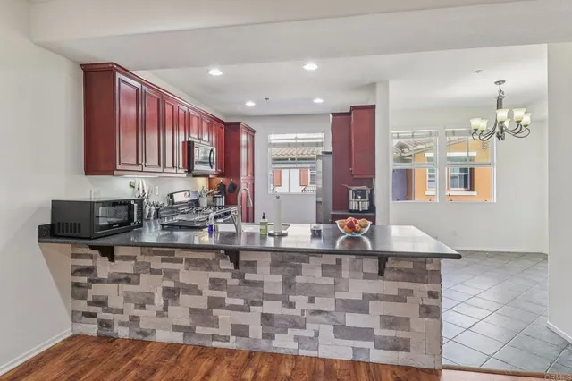 a kitchen with stainless steel appliances granite countertop a stove a sink and a microwave