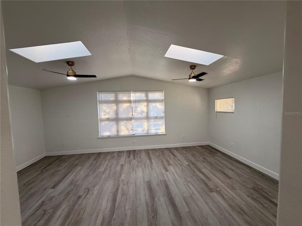 7513 Rustic Drive Tampa, FL 33634 - Photo 14 of 21 an empty room with wooden floor and windows