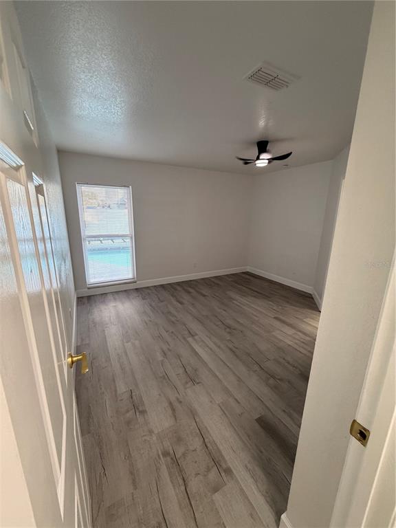 7513 Rustic Drive Tampa, FL 33634 - Photo 20 of 21 an empty room with wooden floor and windows