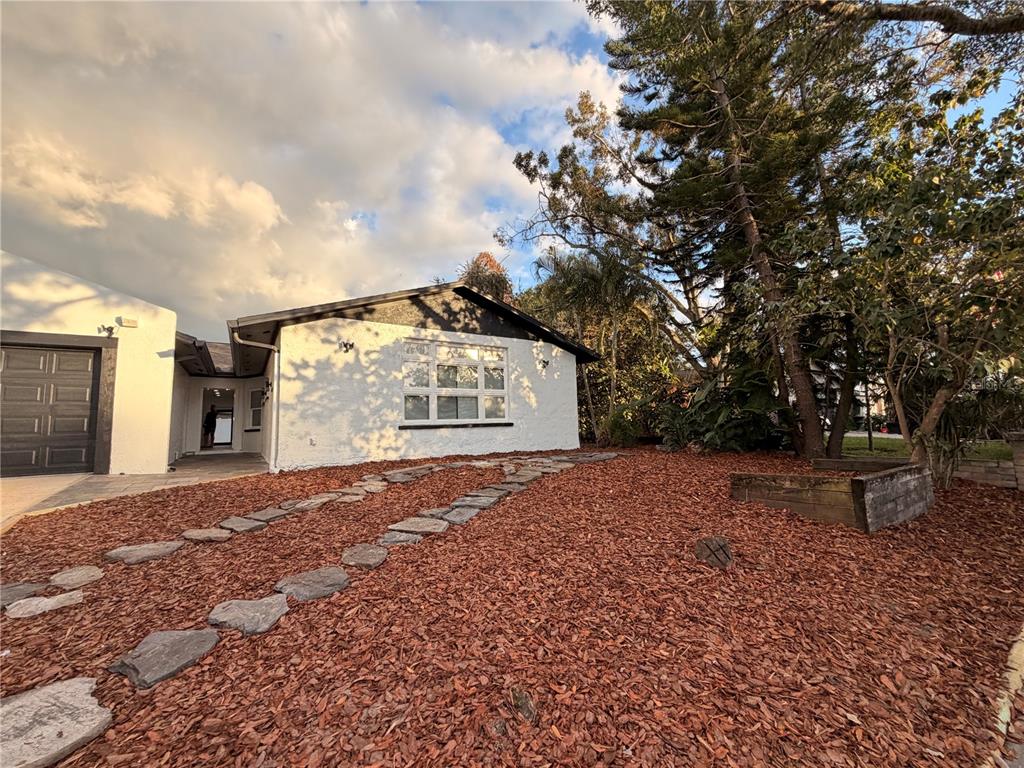 7513 Rustic Drive Tampa, FL 33634 - Photo 2 of 21 a front view of a house with a yard and garage