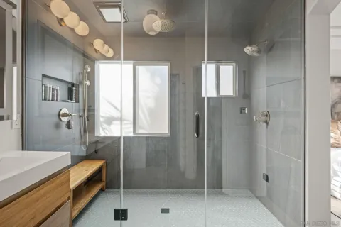 a spacious bathroom with a glass shower door and a sink