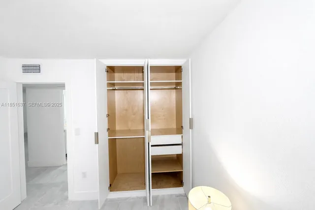 a bedroom with a bed and large windows