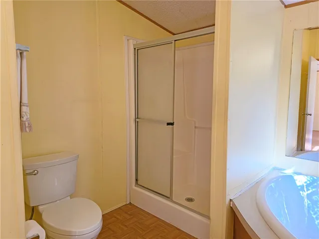 a bathroom with a granite countertop sink toilet and shower