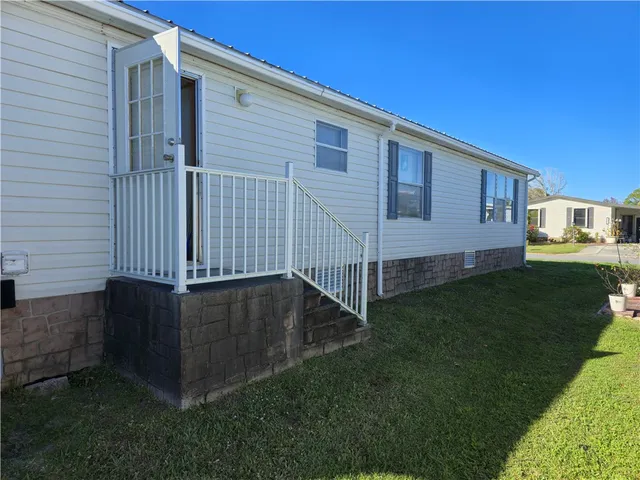 a view of backyard with barbeque grill and wooden fence