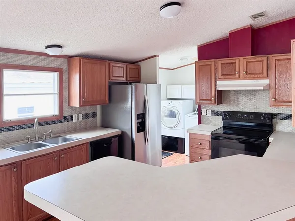 a kitchen with stainless steel appliances a stove refrigerator sink and cabinets