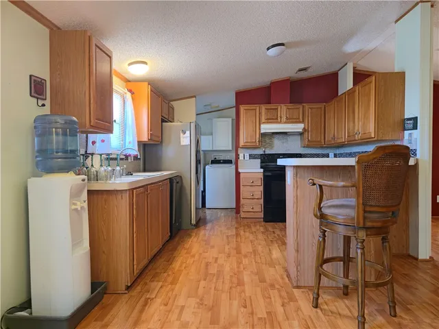 a kitchen with a table chairs refrigerator and wooden cabinets