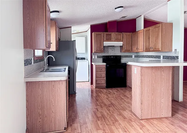 a kitchen with stainless steel appliances granite countertop wooden cabinets a stove top oven a sink and dishwasher