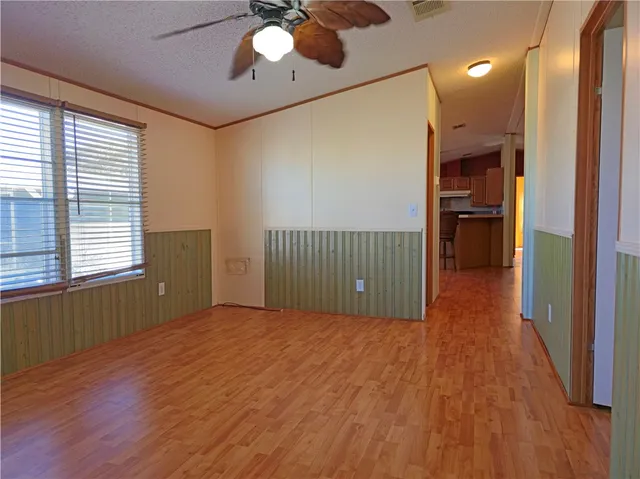 a view of a hallway with wooden floor and a chandelier