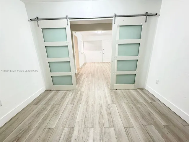 a view of empty room with wooden floor and closet