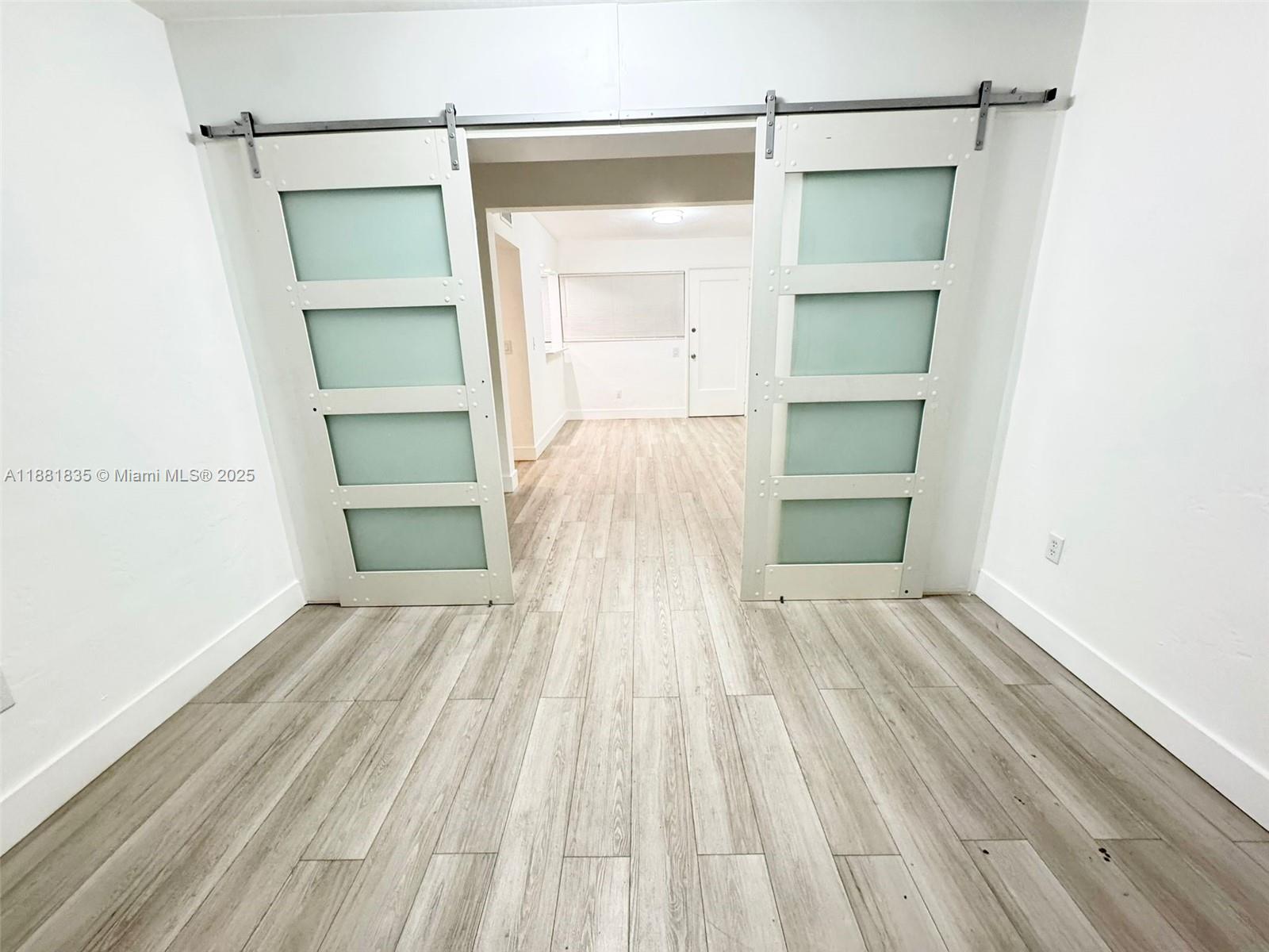 7435 Byron Avenue, Unit 2 Miami Beach, FL 33141 - Photo 11 of 35 a view of empty room with wooden floor and closet