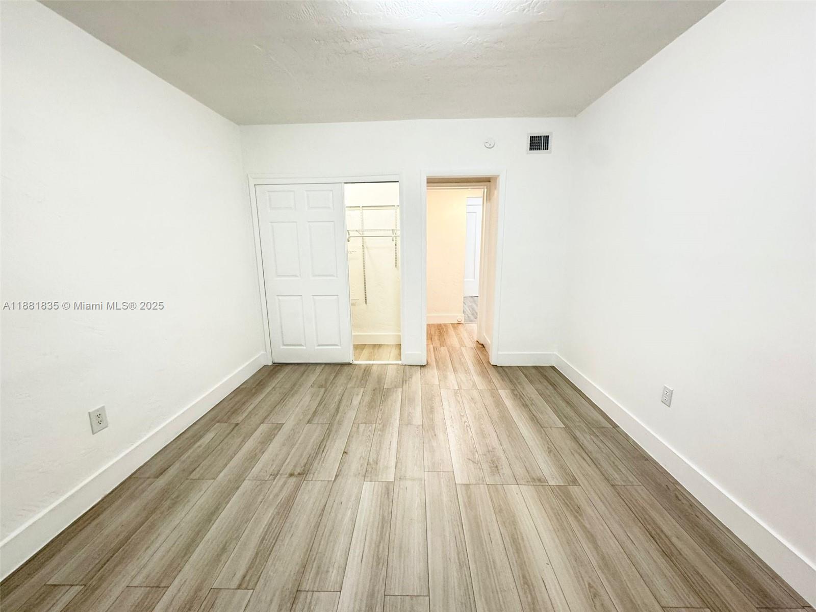 7435 Byron Avenue, Unit 2 Miami Beach, FL 33141 - Photo 18 of 35 a view of a room with wooden floor and white walls