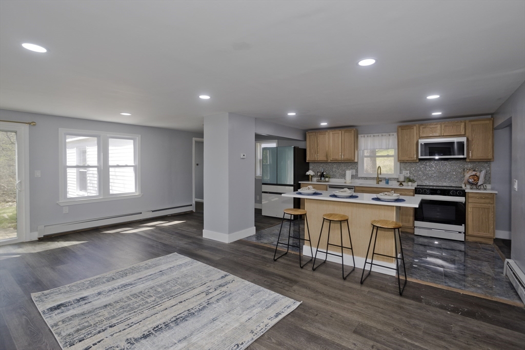 138 Stapleton Road Springfield, MA 01109 - Photo 5 of 38 a open kitchen with granite countertop a stove a sink a island and chairs in it
