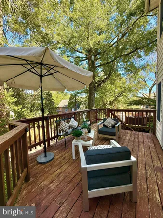 a view of a roof deck with table and chairs under an umbrella with wooden floor