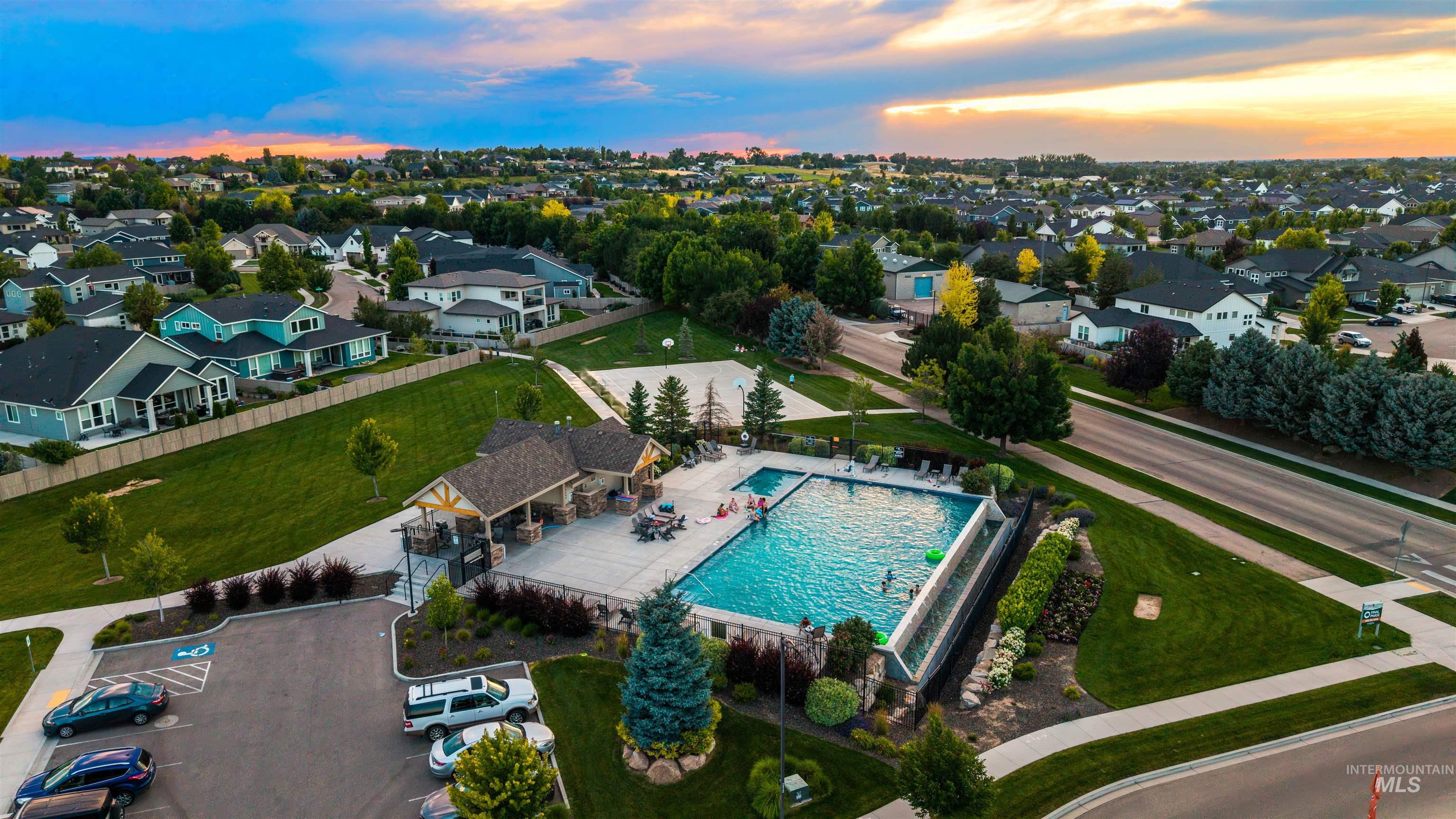 5817 South Gustav Avenue Meridian, ID 83642 - Photo 29 of 33 Community pool and clubhouse featuring a covered patio, multiple lounge chairs, and a paved parking area