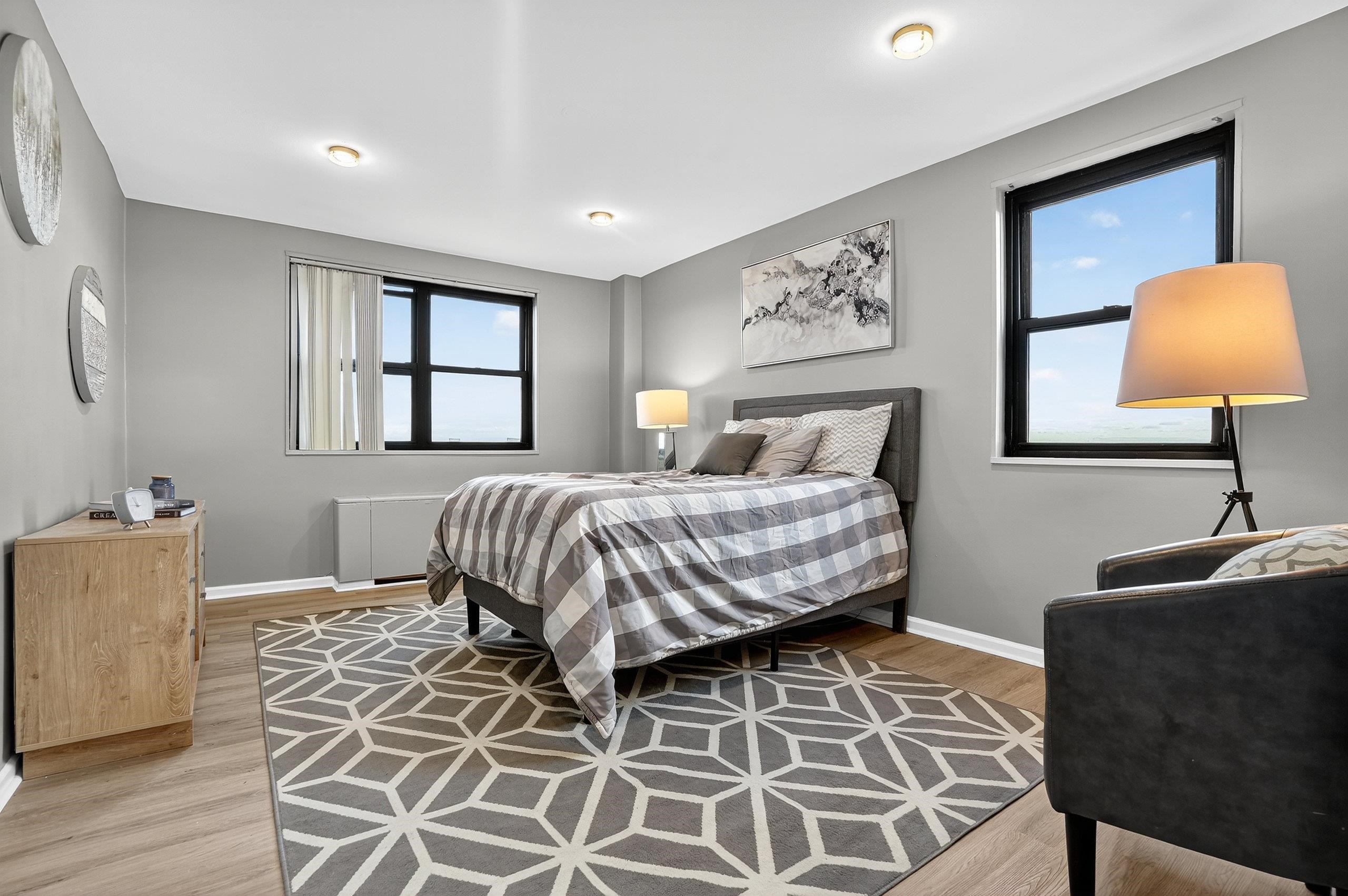 1225 John F. Kennedy Boulevard, Unit 12K Bayonne, NJ 07002 - Photo 15 of 18 a bedroom with a bed lamp and window