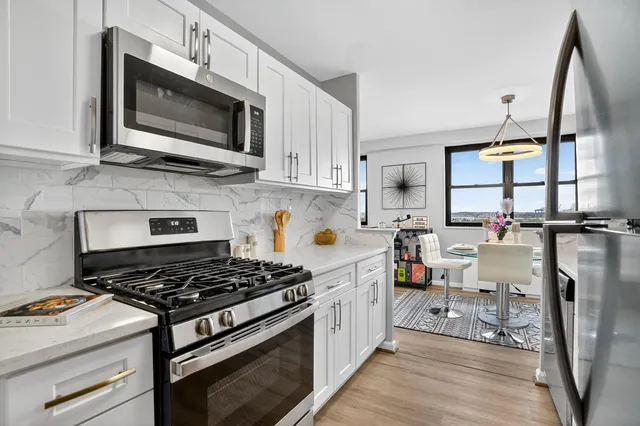 a kitchen with stainless steel appliances a stove a sink cabinets and a counter top space