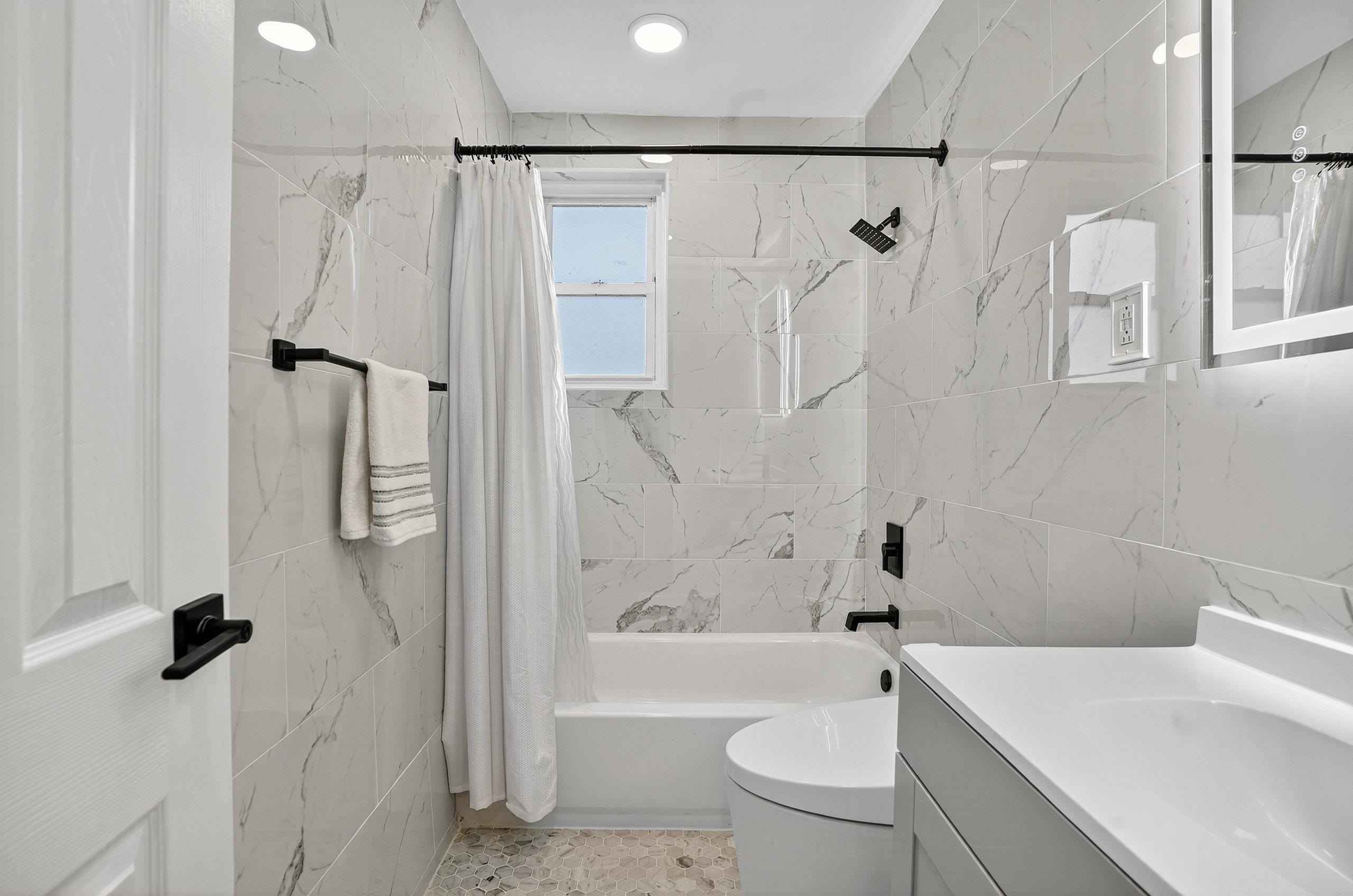 1225 John F. Kennedy Boulevard, Unit 12K Bayonne, NJ 07002 - Photo 6 of 18 a bathroom with a shower a toilet and a sink