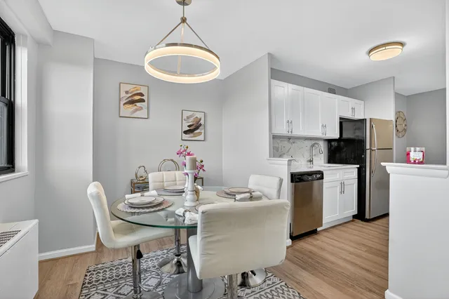 a kitchen with a dining table chairs and refrigerator