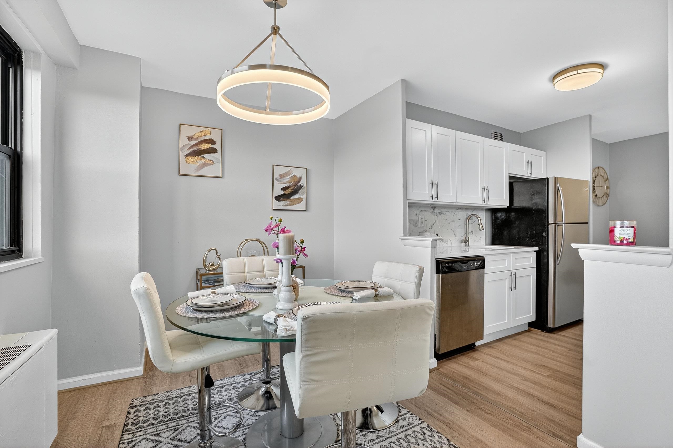 1225 John F. Kennedy Boulevard, Unit 12K Bayonne, NJ 07002 - Photo 7 of 18 a kitchen with a dining table chairs and refrigerator