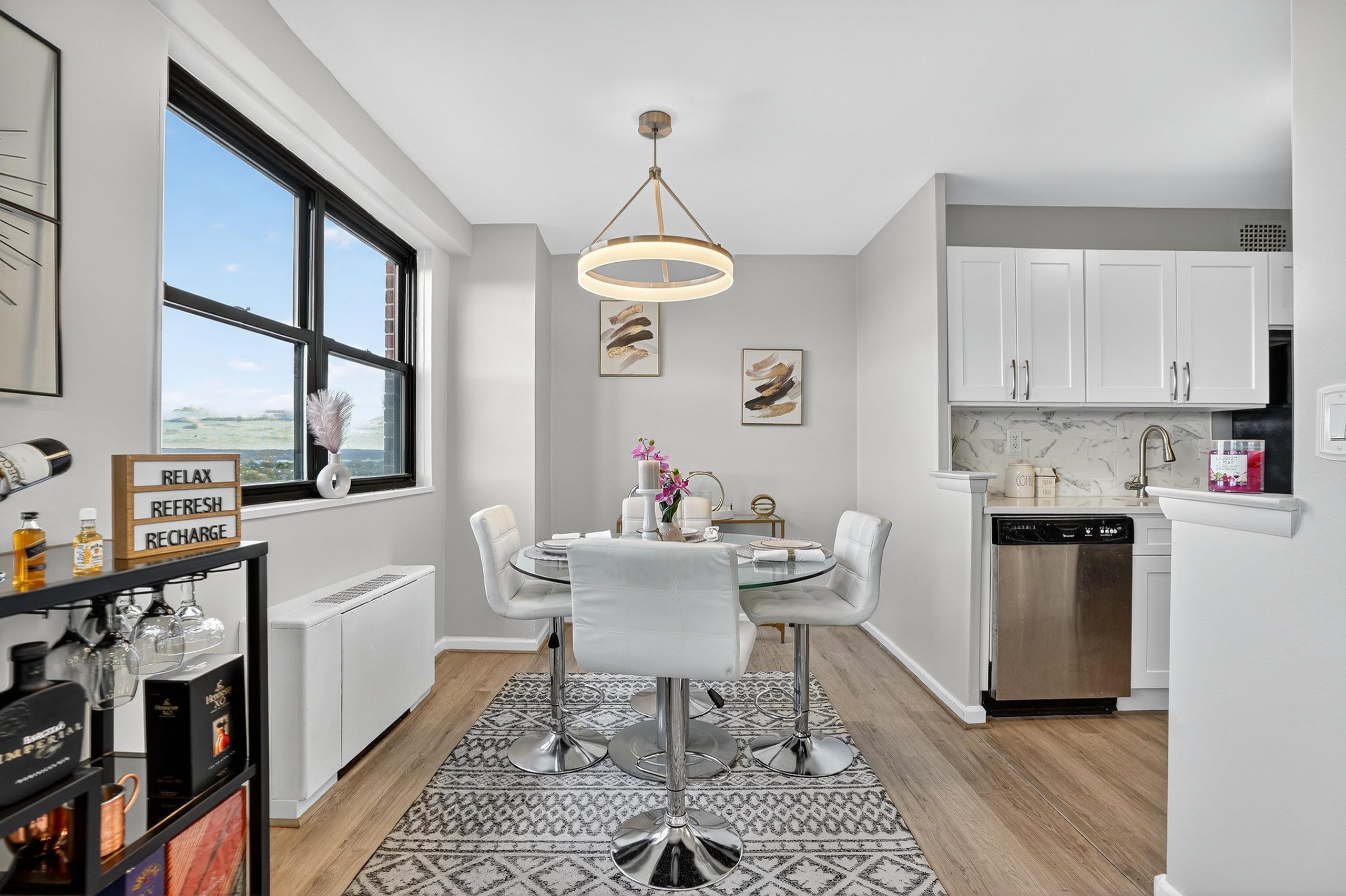 1225 John F. Kennedy Boulevard, Unit 12K Bayonne, NJ 07002 - Photo 10 of 18 a kitchen with a dining table cabinets appliances and a dining table