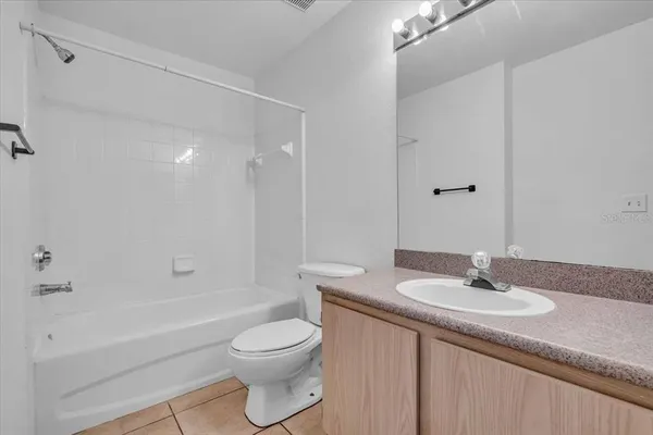 a bathroom with a granite countertop sink a toilet and shower