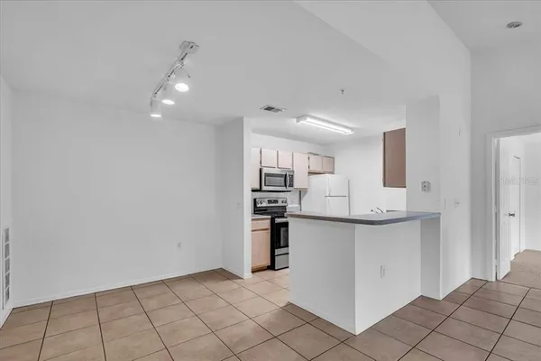 a view of kitchen with stainless steel appliances granite countertop cabinets and chandelier