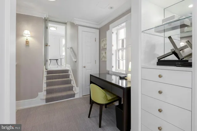 a view of a hallway with furniture and a window