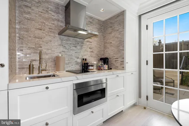 a kitchen with stainless steel appliances white cabinets and a window