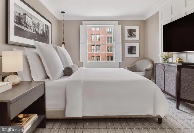 a bedroom with a bed and a flat tv screen on dresser