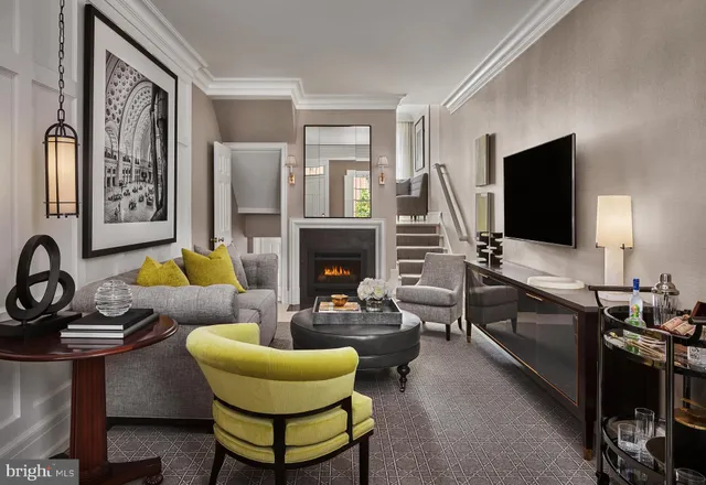 a living room with furniture a flat screen tv and a fireplace