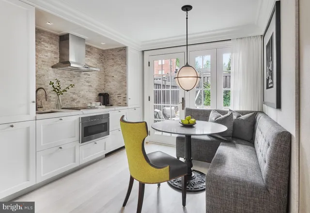 a living room with stainless steel appliances granite countertop furniture a fireplace a rug and a window