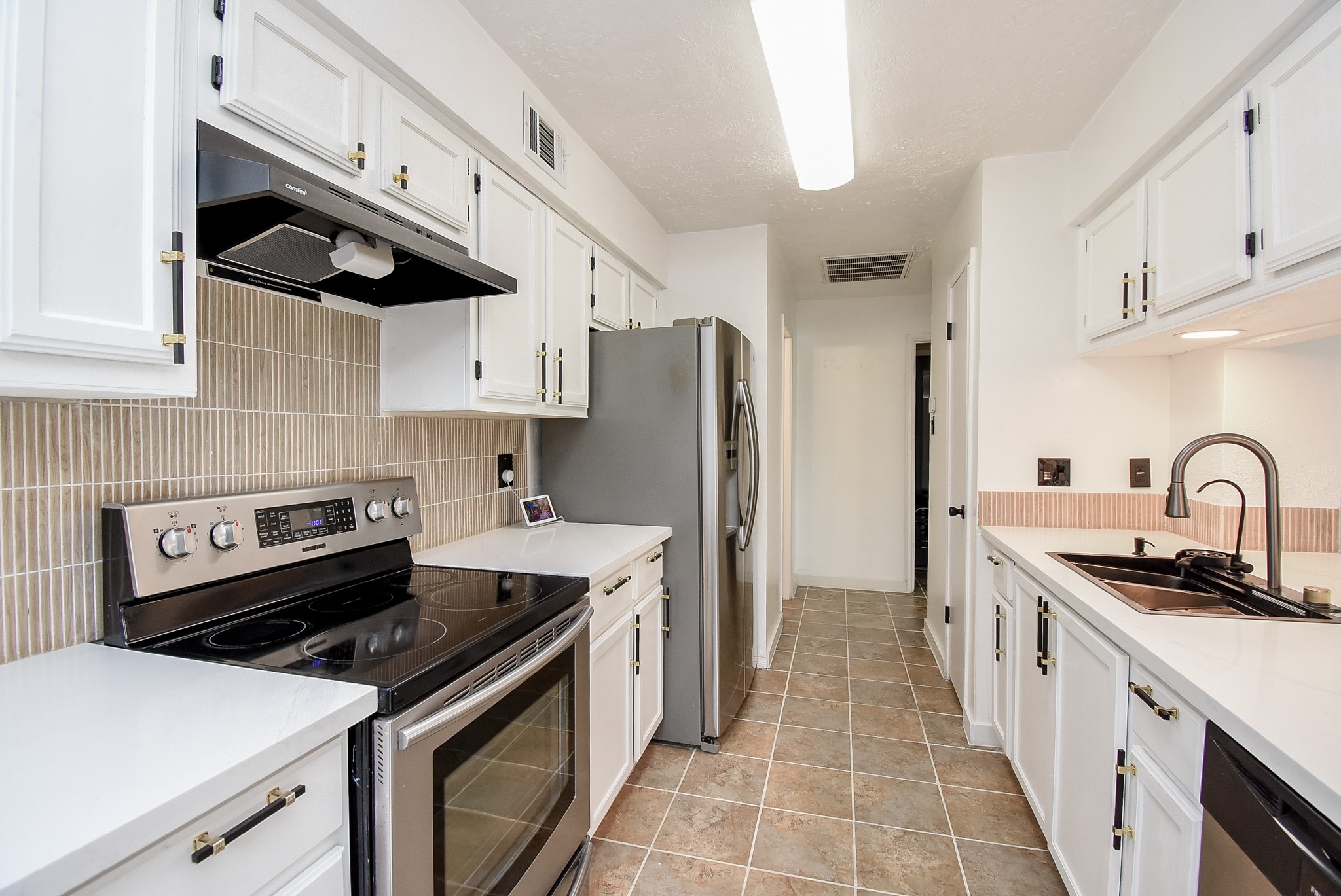 8715 Vinkins Road Houston, TX 77071 - Photo 14 of 48 The beautifully updated kitchen features quartz countertops, a new sink and faucet, refreshed cabinetry, stainless steel appliances, and a convenient pass-through that opens to the family room, making entertaining effortless