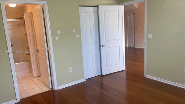 an empty room with wooden floor and entrance